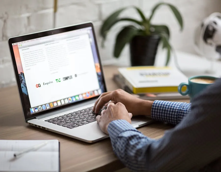 Minimal designer workspace — laptop, notebook, and coffee on a light desk